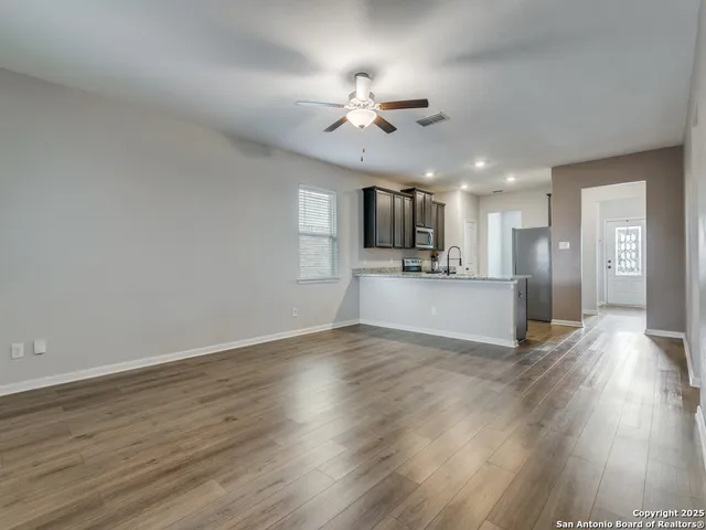 a view of a kitchen with a sink a microwave and floor to ceiling window