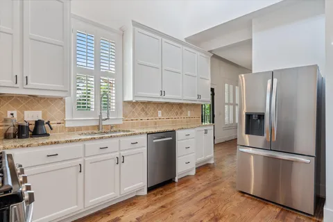 a kitchen with granite countertop white cabinets and white appliances