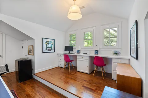 a bedroom with a bed and a flat tv screen on dresser