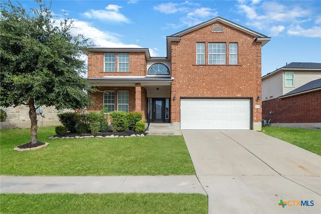 a front view of a house with a yard and garage