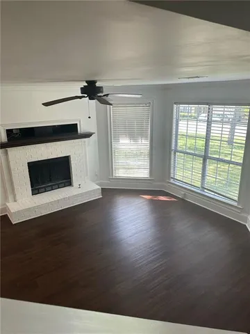 a view of wooden floor fire place and windows in a room