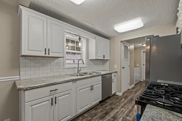 a kitchen with a sink stove and cabinets