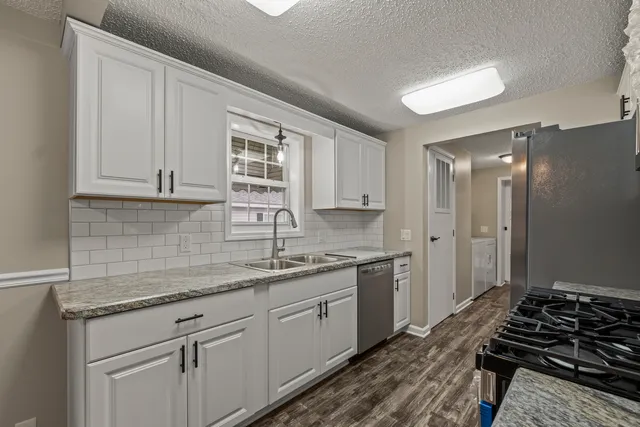 a kitchen with a sink stove and cabinets