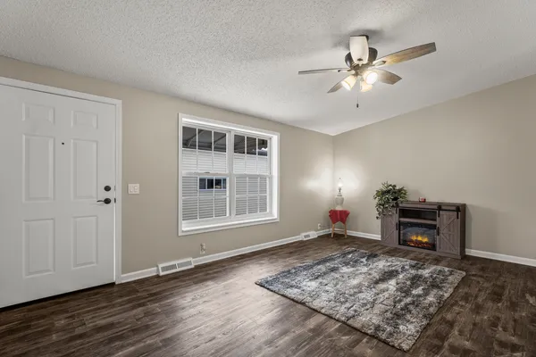 a view of a livingroom with wooden floor and a chandelier