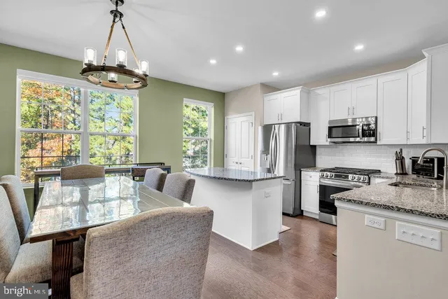 a view of a dining room with furniture a chandelier and window