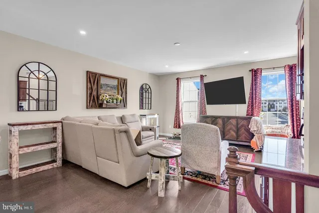 a living room with furniture a flat screen tv and a window