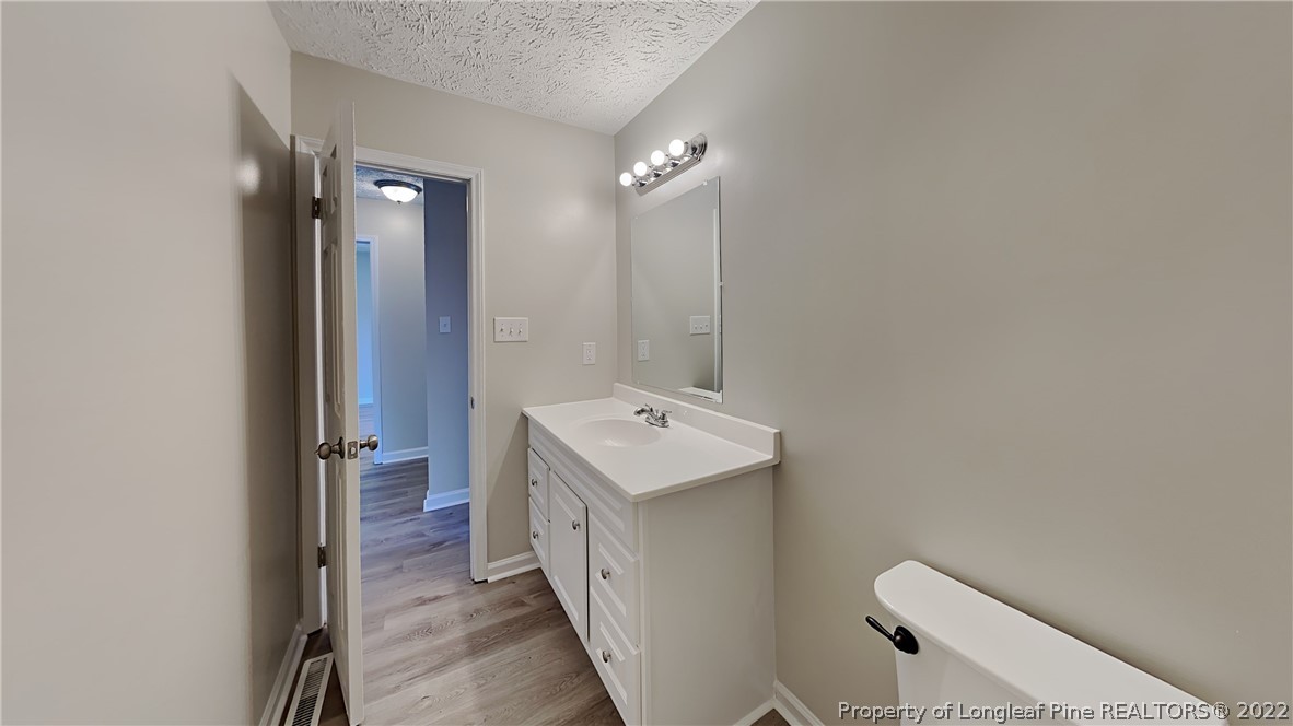 1153 Hoke Loop Road Fayetteville, NC 28314 - Photo 16 of 20 a bathroom with a sink a toilet and shower