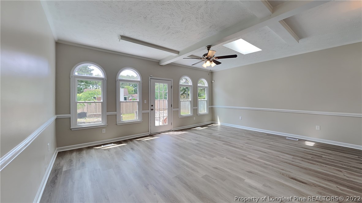 1153 Hoke Loop Road Fayetteville, NC 28314 - Photo 18 of 20 an empty room with wooden floor fan and windows