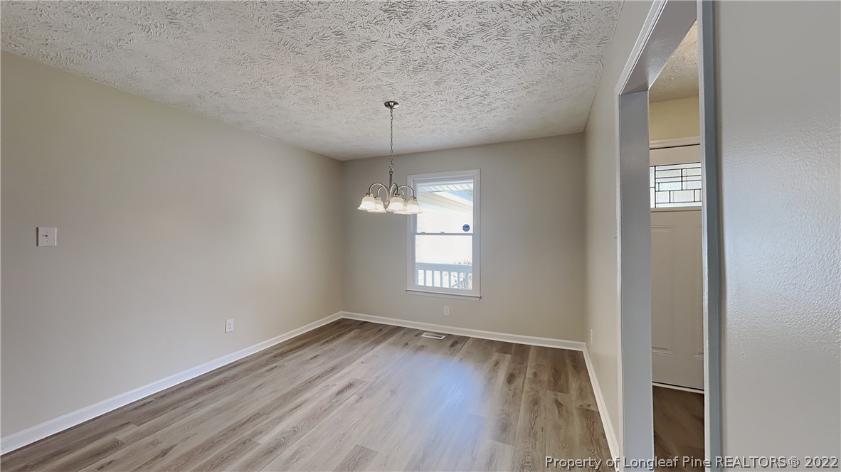 1153 Hoke Loop Road Fayetteville, NC 28314 - Photo 3 of 20 an empty room with wooden floor and windows