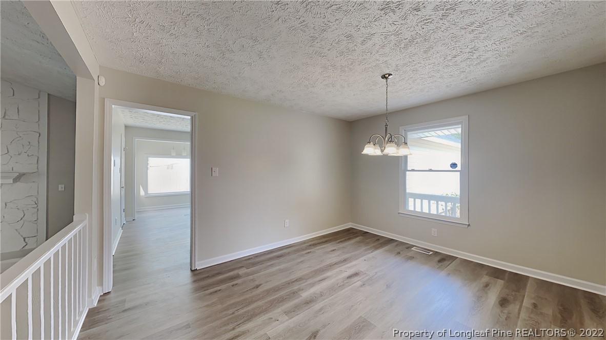 1153 Hoke Loop Road Fayetteville, NC 28314 - Photo 4 of 20 a view of an empty room with wooden floor and a window