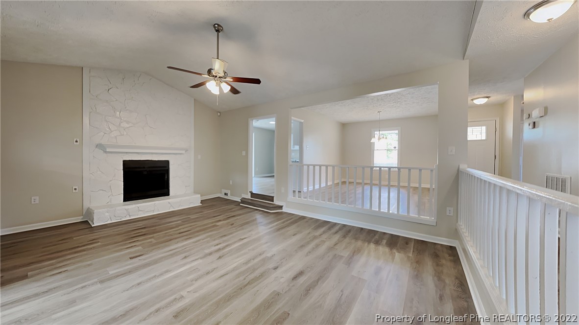 1153 Hoke Loop Road Fayetteville, NC 28314 - Photo 5 of 20 a view of an empty room with wooden floor fireplace and a window