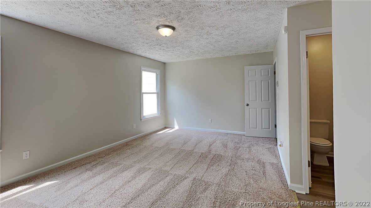 1153 Hoke Loop Road Fayetteville, NC 28314 - Photo 8 of 20 an empty room with wooden floor and windows