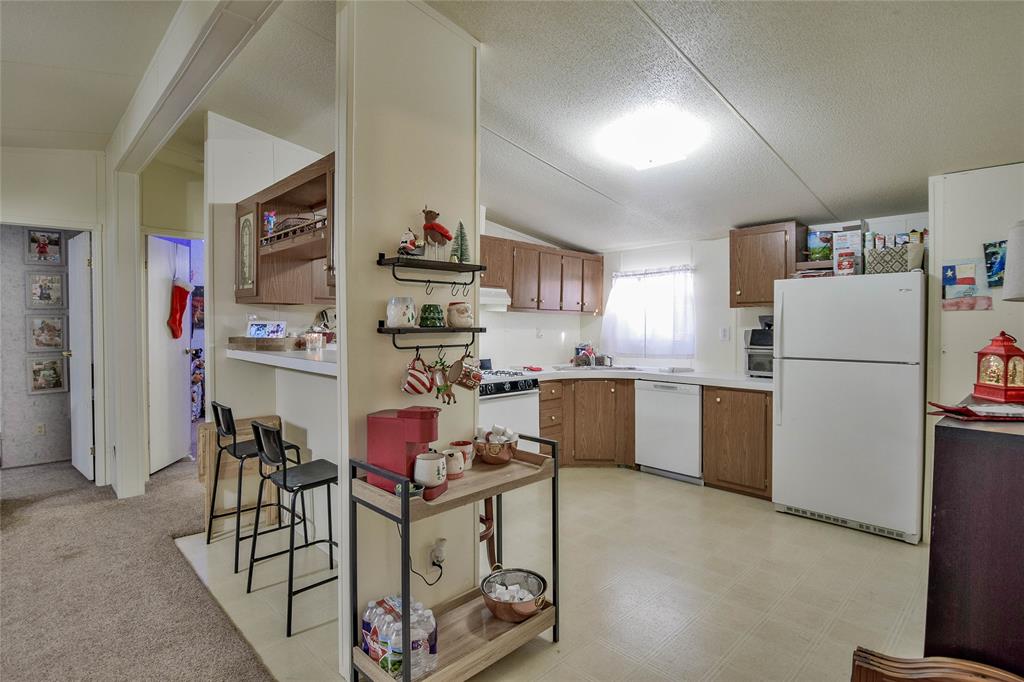 214 Gandy Street Lipan, TX 76462 - Photo 12 of 40 a kitchen with stainless steel appliances granite countertop a refrigerator and a stove top oven