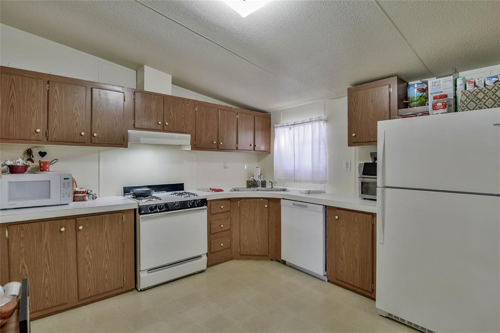 214 Gandy Street Lipan, TX 76462 - Photo 15 of 40 a kitchen with stainless steel appliances granite countertop a refrigerator a stove a sink and a refrigerator