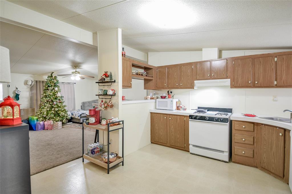 214 Gandy Street Lipan, TX 76462 - Photo 16 of 40 a kitchen with granite countertop a sink cabinets and appliances