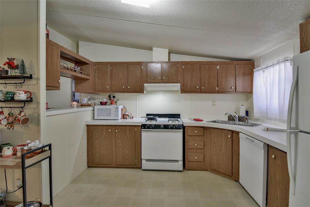 214 Gandy Street Lipan, TX 76462 - Photo 20 of 40 a kitchen with stainless steel appliances granite countertop a sink stove and refrigerator