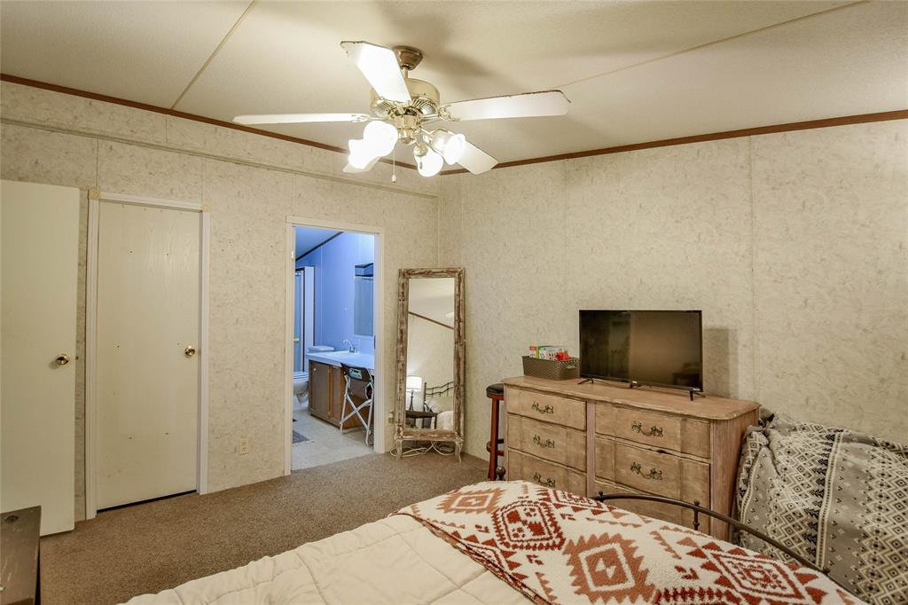 214 Gandy Street Lipan, TX 76462 - Photo 24 of 40 a bedroom with furniture and a flat screen tv