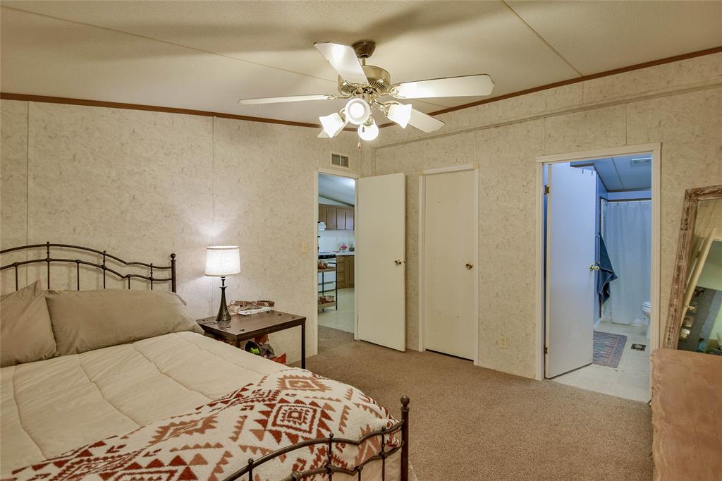 214 Gandy Street Lipan, TX 76462 - Photo 25 of 40 a bedroom with a bed and a chandelier