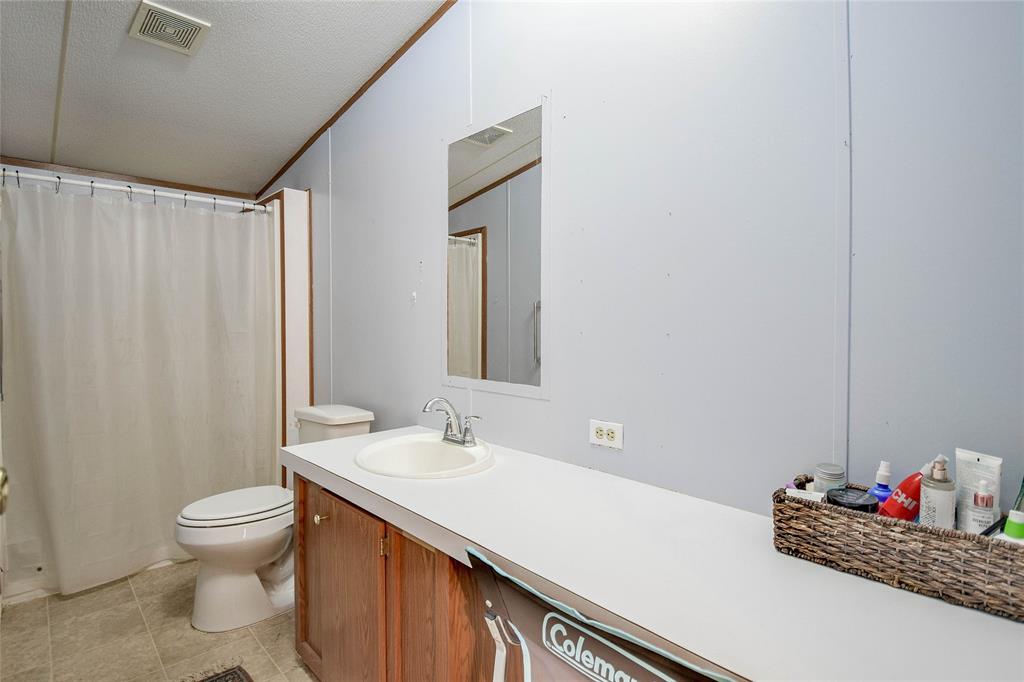 214 Gandy Street Lipan, TX 76462 - Photo 26 of 40 a bathroom with a sink toilet and shower