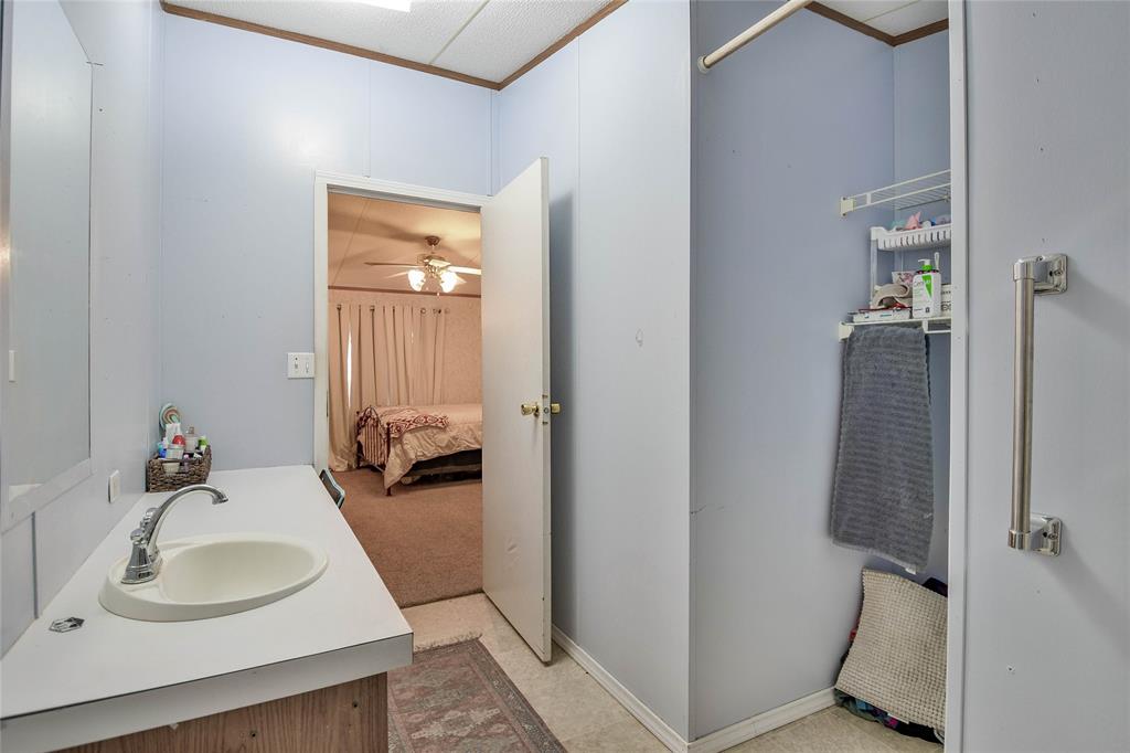 214 Gandy Street Lipan, TX 76462 - Photo 27 of 40 a en suite bathroom with a sink and mirror