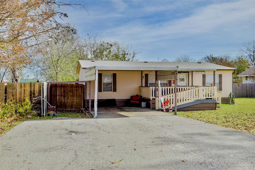 214 Gandy Street Lipan, TX 76462 - Photo 3 of 40 a view of a house with wooden fence next to a road