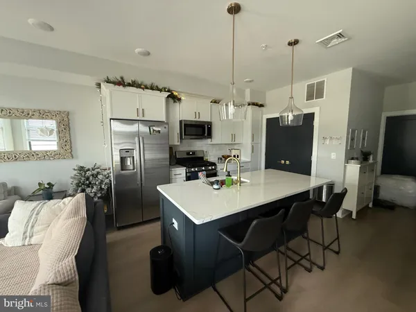 a kitchen with stainless steel appliances a table chairs refrigerator and microwave