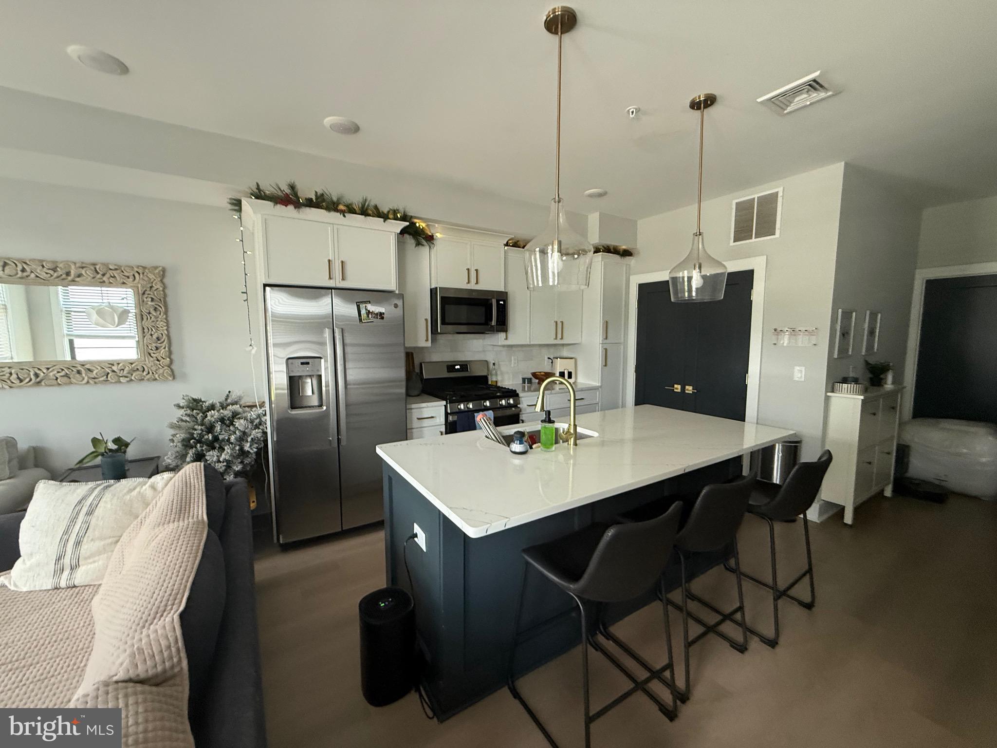 7521 Ridge Avenue Philadelphia, PA 19128 - Photo 4 of 13 a kitchen with stainless steel appliances a table chairs refrigerator and microwave