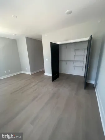 a view of an empty room with closet and utility room