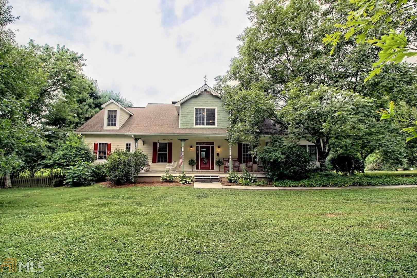 a front view of a house with garden and trees