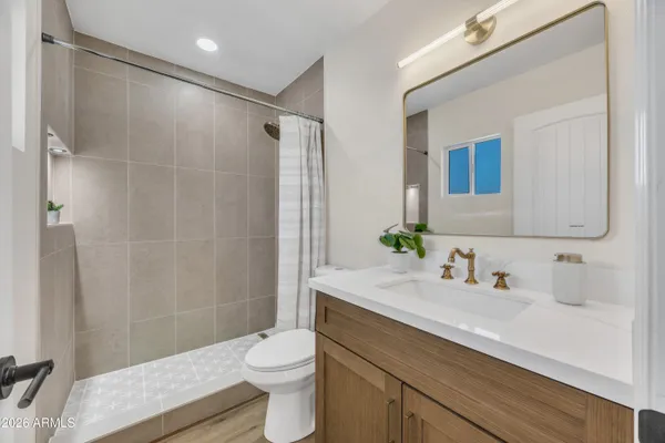 a bathroom with a sink a toilet and shower