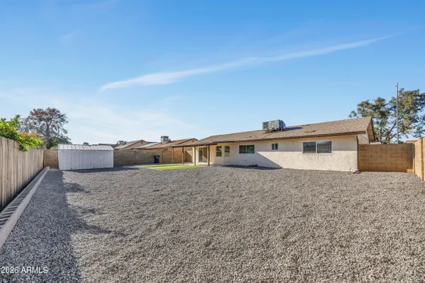 a front view of house with yard and trees in the background