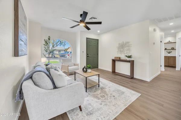 a living room with furniture and a wooden floor