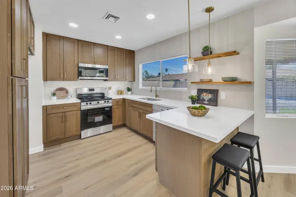 a kitchen with a sink a stove a refrigerator and chairs