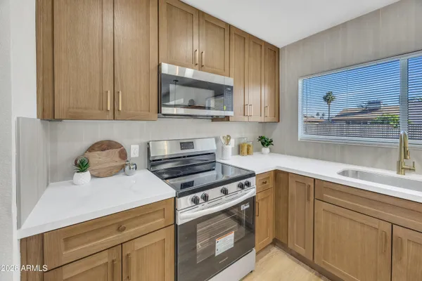 a kitchen with stainless steel appliances a stove cabinets and a window