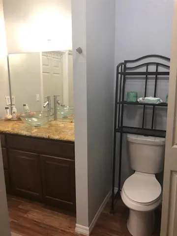 a bathroom with a granite countertop toilet sink and mirror