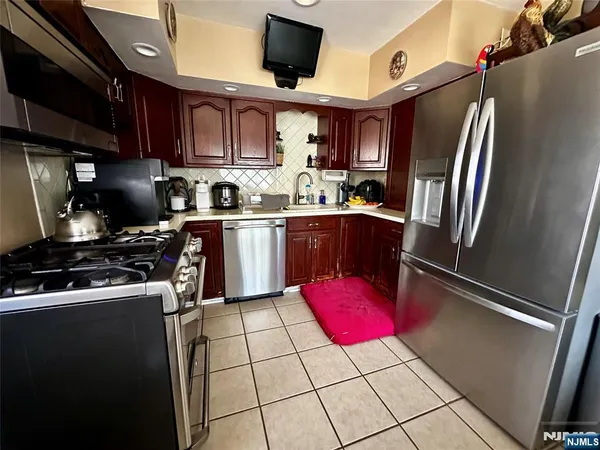 a kitchen with stainless steel appliances granite countertop a stove refrigerator sink and cabinets