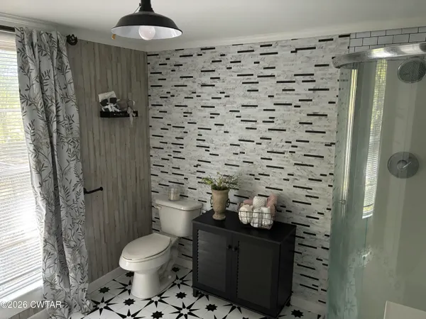 a bathroom with a toilet and a shower