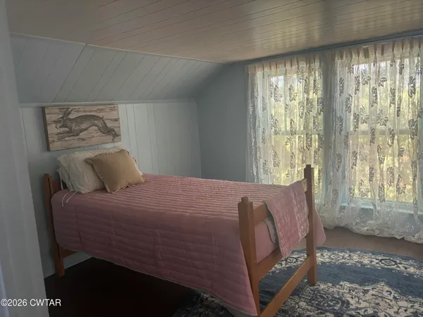 a view of a bedroom with wooden floor and a sink