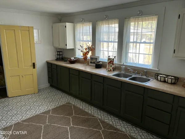 a kitchen with a sink window and cabinets
