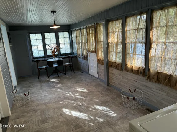 a dining room with furniture and a large window
