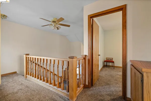 a view of a hallway with closet and a chandelier fan