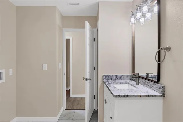 a bathroom with a granite countertop sink and a mirror