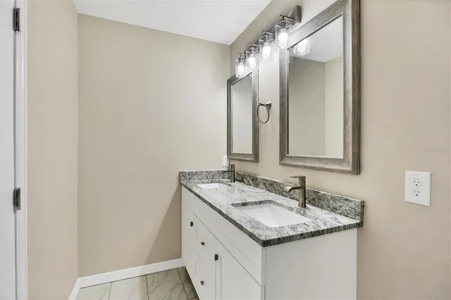 a bathroom with a granite countertop sink and a mirror