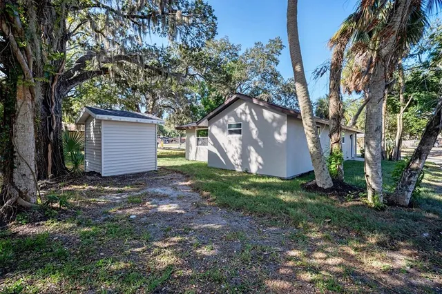 a view of a house with a yard and tree