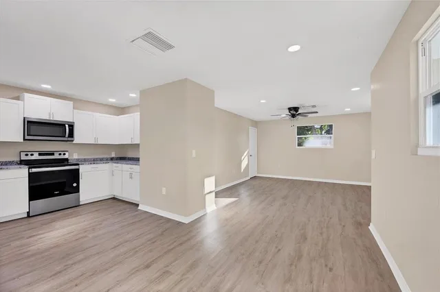 a view of kitchen with wooden floor and electronic appliances
