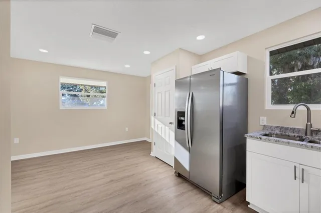 a kitchen with stainless steel appliances granite countertop a refrigerator and a stove top oven