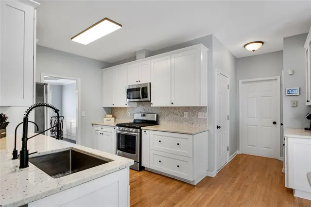 a kitchen with white cabinets and stainless steel appliances