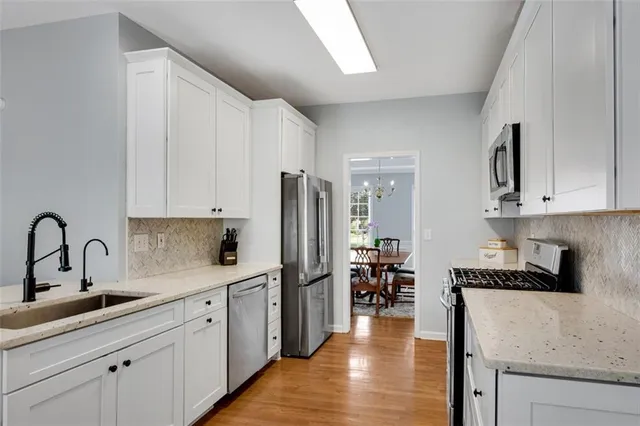 a kitchen with stainless steel appliances a stove sink microwave and cabinets
