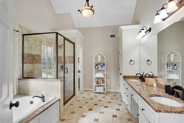 a spacious bathroom with a granite countertop sink a mirror and shower