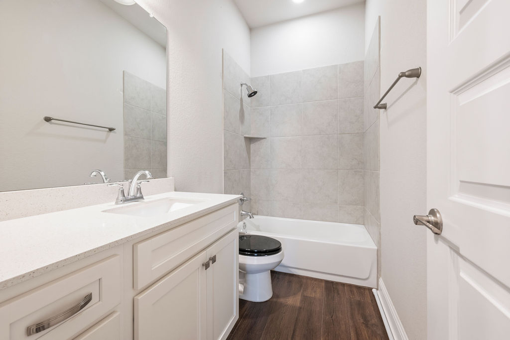2032 Base Burner Path Leander, TX 78641 - Photo 24 of 34 Bathroom vanity with a white rectangular undermount sink, a chrome faucet, and a light-colored solid surface countertop